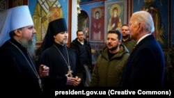 Президент України Володимир Зеленський і президент США Джо Байден (праворуч) спілкуються з главою ПЦУ Епіфанієм (ліворуч) у Михайлівському Золотоверхому соборі. Київ, 20 лютого 2023 року
