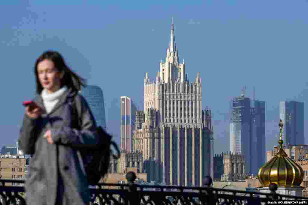 Жанчына ідзе па мосце на фоне будынку Міністэрства замежных справаў Расеі ў цэнтры Масквы, 12 кастрычніка. 