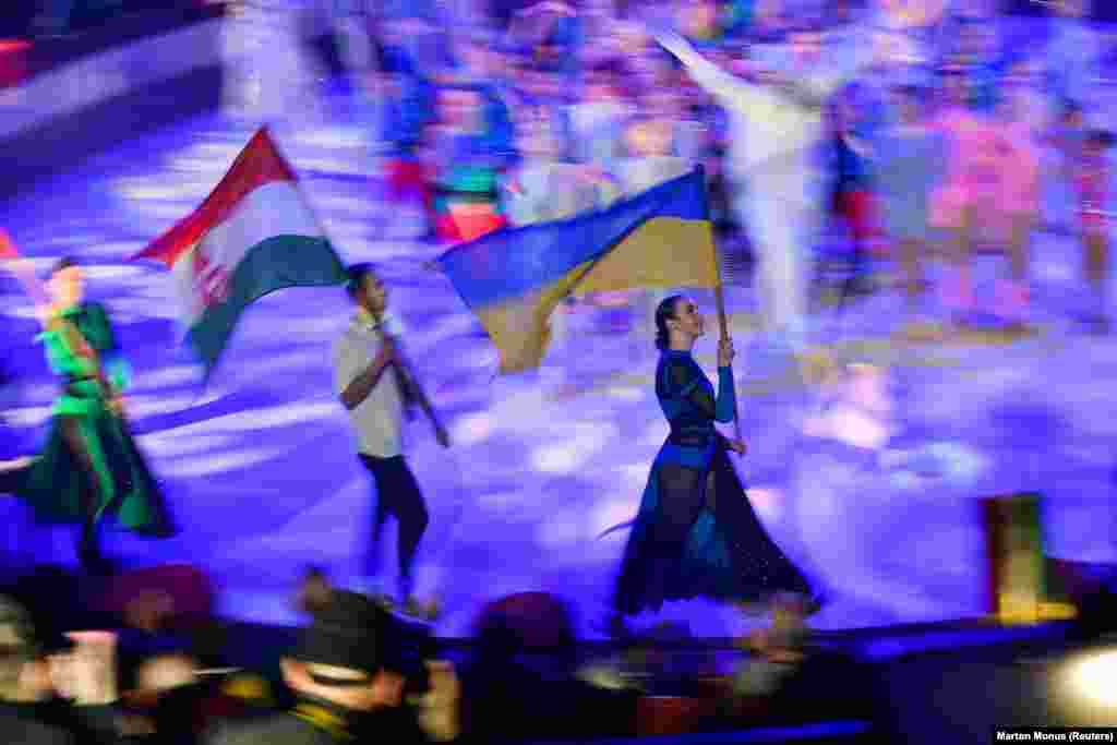 Артысты нясуць сьцягі Вугоршчыны і Ўкраіны падчас Міжнароднага фэстывалю дзіцячага цыркавога мастацтва "Яскрава-Арэна Днепр" у Будапэшце.