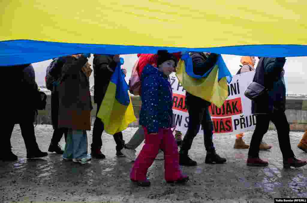 Діти бавилися та йшли під великим прапором 