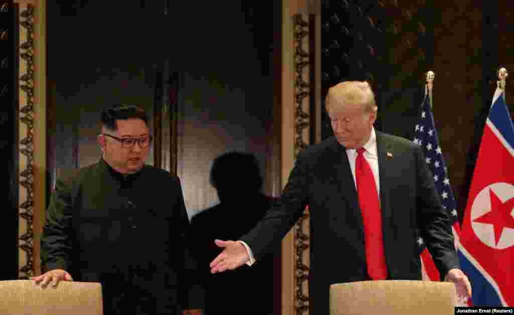 Дональд Трамп менен Ким Чен Ын документке кол коюлар астында. 