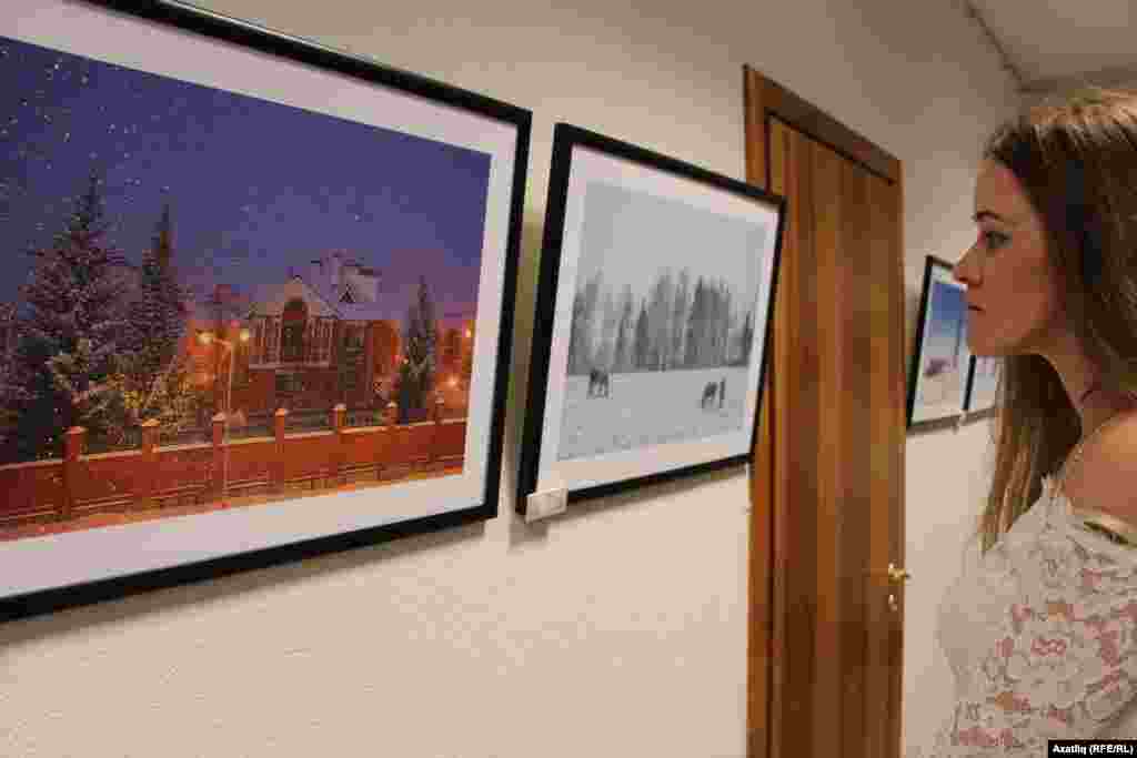 Күргәзмә фотолары белән танышучы кыз