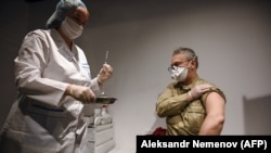Орусиялык тургун "Спутник V" ("Gam-COVID-Vac") вакцинасы менен эмделүүдө. ГУМ, Москва шаары. 2021-жылдын 18-январы. 