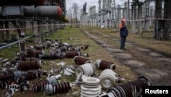 Працівник на високовольтній підстанції «Укренерго», пошкодженій російськими ударами, 10 листопада 2022 року