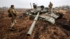 Українські військові оглядають застряглий російський танк у селі Нова Басань на Чернігівщині після відновлення контролю над цим населеним пунктом, 1 квітня 2022 року