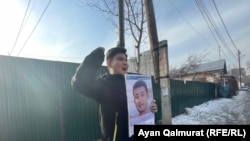 Байболат Кунболатулы с портретом своего брата проводит пикет напротив консульства Китая. Через некоторое время он был задержан полицией. Алматы, 1 февраля 2021 года.