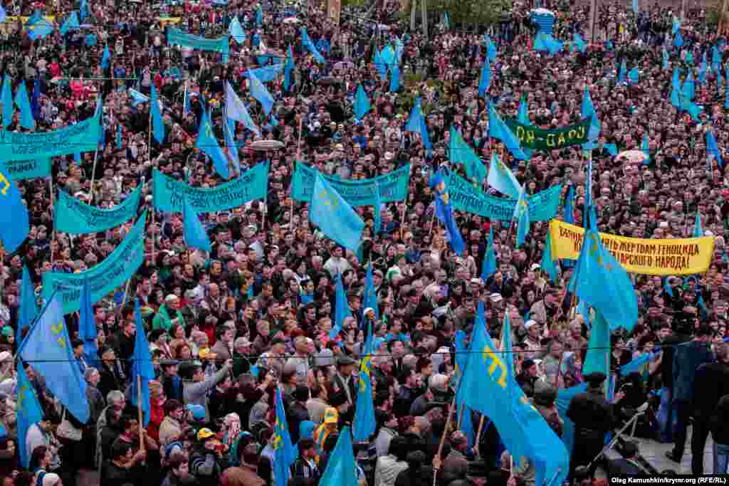 18. Год 2014-й, Симферополь, пос. Ак-Мечеть. Несмотря на противодействие российских властей Крыма, число собравшихся на траурный митинг крымских татар не стало меньше. Особенно бросается в глаза отсутствие государственных флагов Украины: сине-желтые стяги и тризубы - под фактическим запретом.