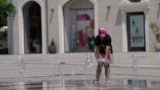 Stanovnica Prištine se rashlađuje u fontani u glavnom gradu Kosova, gdje su temperature 26. juna dostigle 36 stepeni Celzijusa.